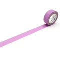 A roll of purple masking tape is lying on a white surface, with a single strip of tape extending from the end of the roll.