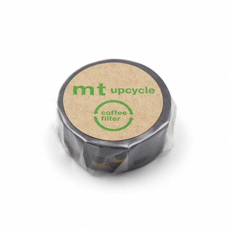 A black coffee filter wrapped in a clear plastic bag, with a cardboard label that reads "mt upcycle coffee filter".