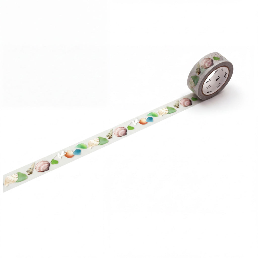 A roll of decorative tape with a pattern of colorful leaves and flowers on it, lying on a white surface.