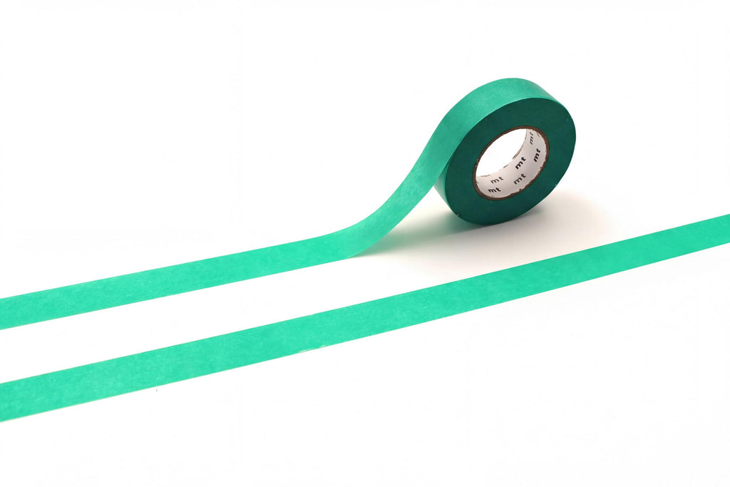 A roll of green tape is lying on a white surface, with a green line extending from the tape.