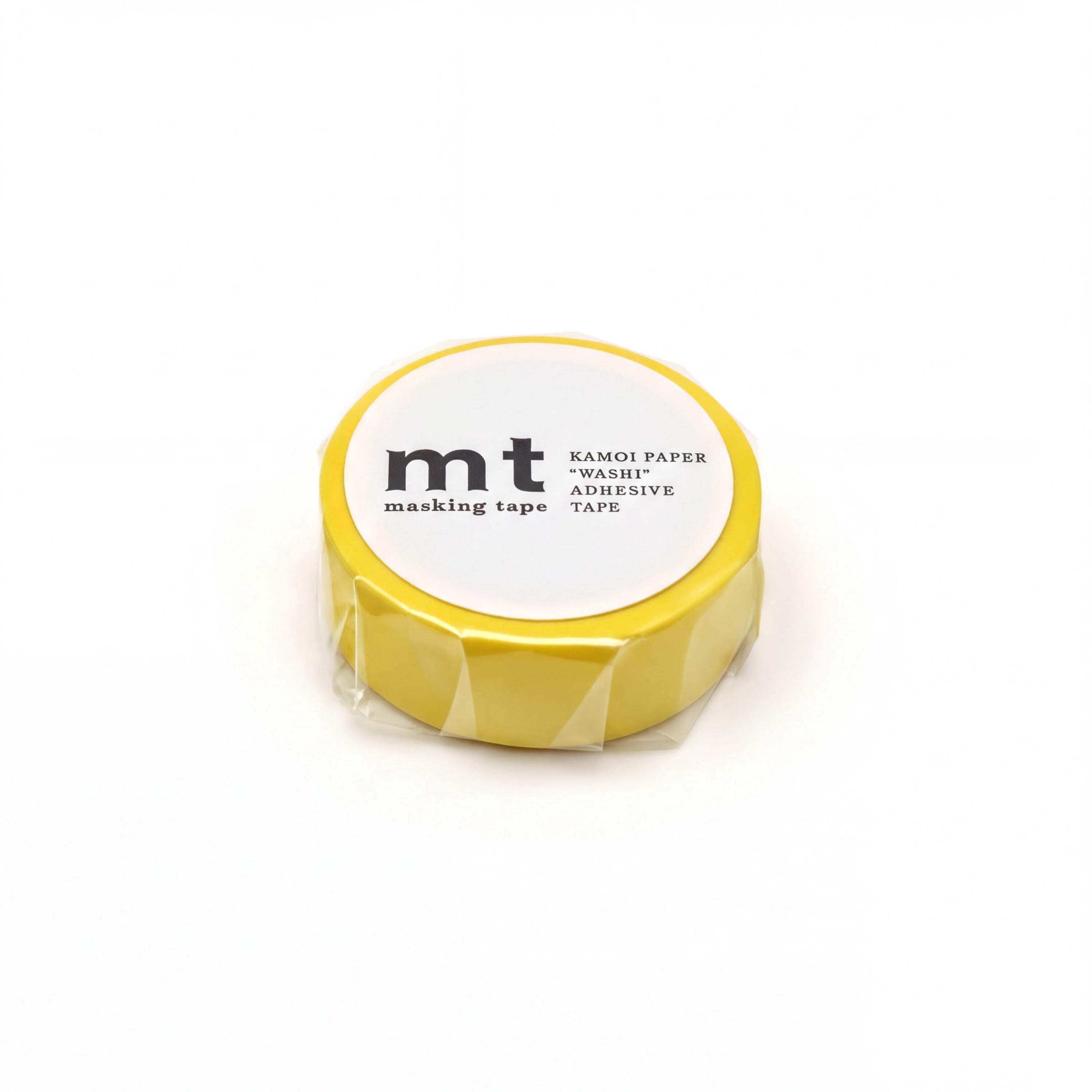 A yellow masking tape roll with a white label that reads "KAMOI PAPER MASKI ADHESIVE TAPE".