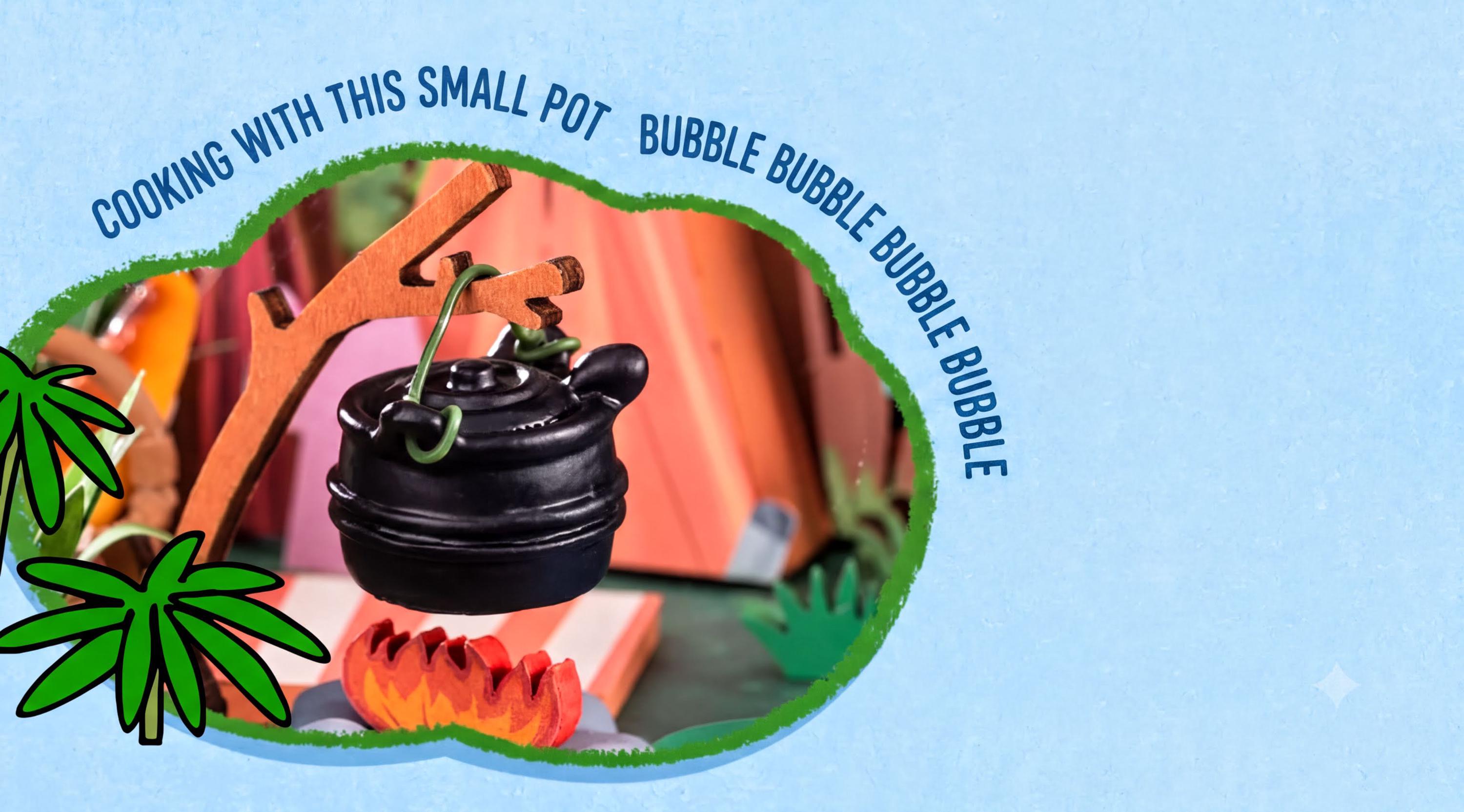 A small black teapot is suspended from a wooden stick, with a fire burning underneath, in a whimsical scene framed by a green border.