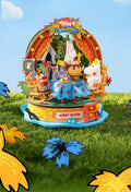 A whimsical, colorful toy set featuring various characters and objects, including a horse, flowers, and a sign that reads "Merry Bloom".