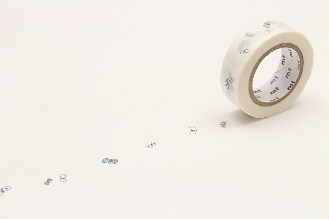 A roll of white tape with black designs on it, lying on a plain white surface.