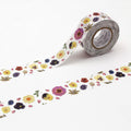 A roll of floral patterned tape is placed on a white surface, with a second roll of tape lying next to it.
