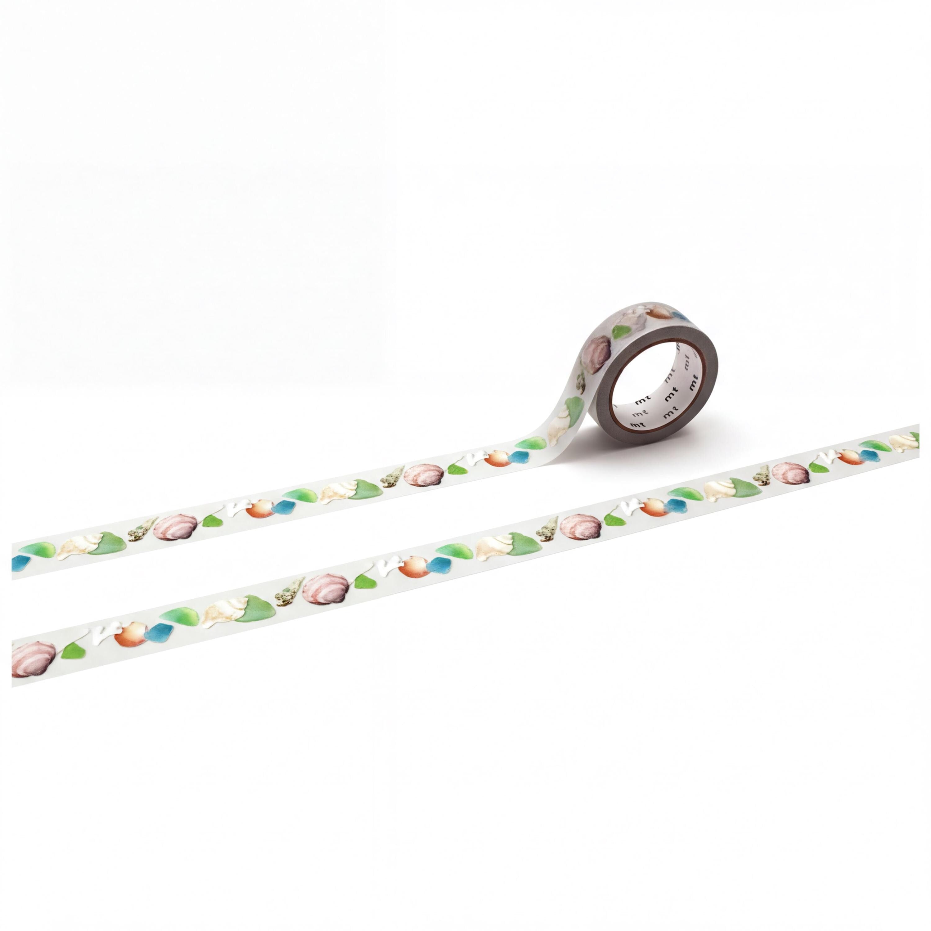 a roll of patterned tape with a repeating design of leaves and flowers on it, lying on a white surface.