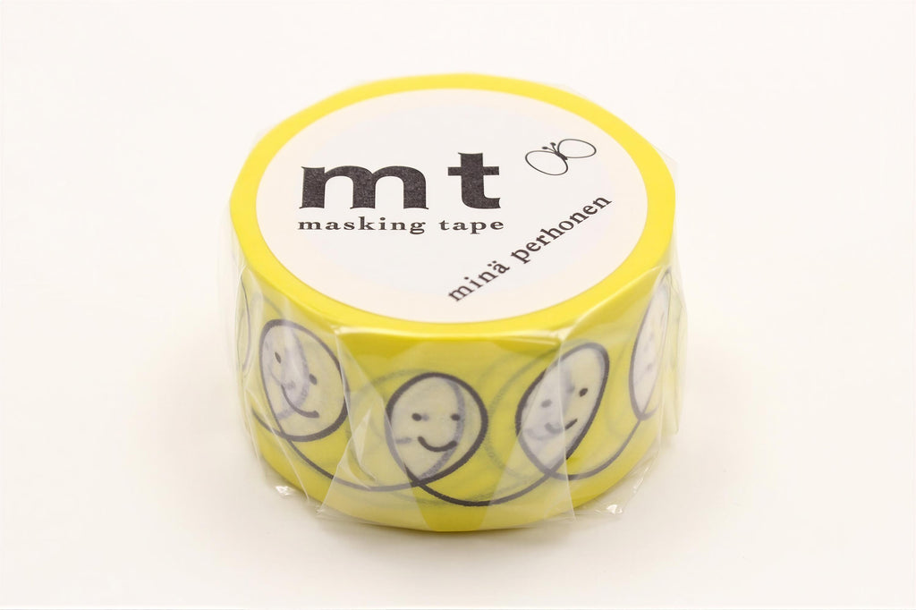 A yellow roll of masking tape with a design of smiling faces on it.
