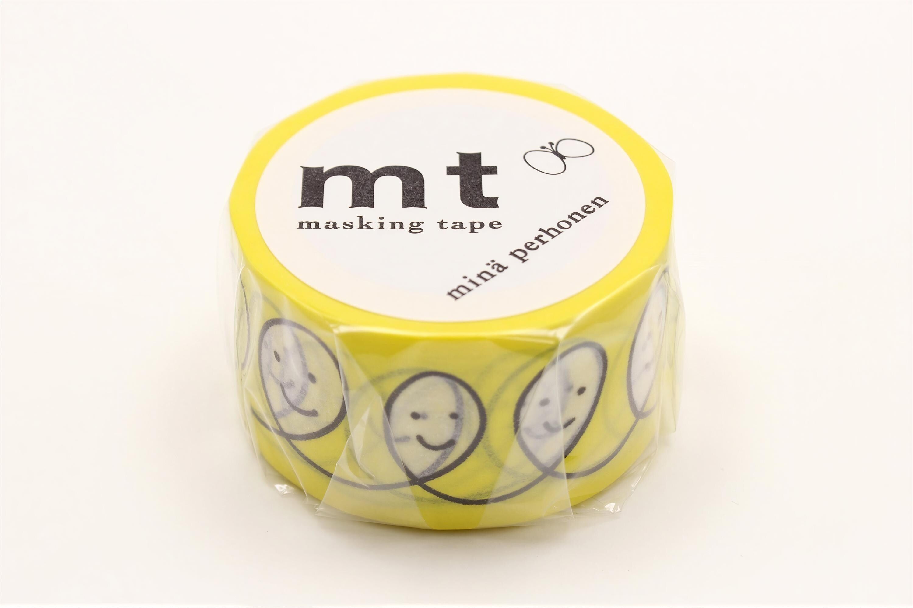 A yellow roll of masking tape with a design of smiling faces on it.